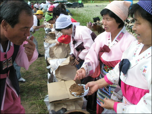 리동춘 동사장이 된장을 직접 맛보고 있다. 